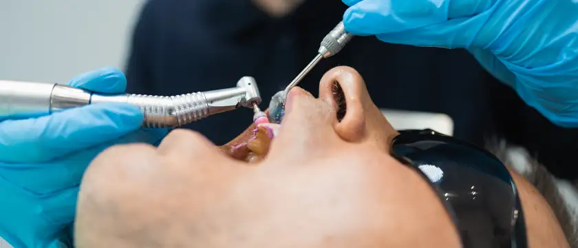 Paciente recibiendo limpieza dental profesional en clínica dental