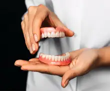 Dentista mostrando prótesis dental al paciente